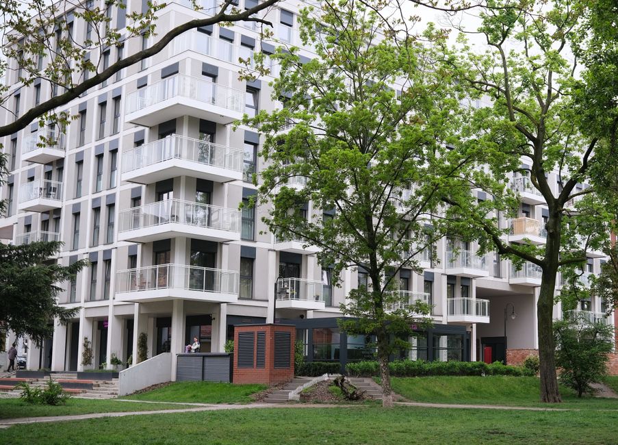 Contemporary urban apartment complex surrounded by lush trees and greenery