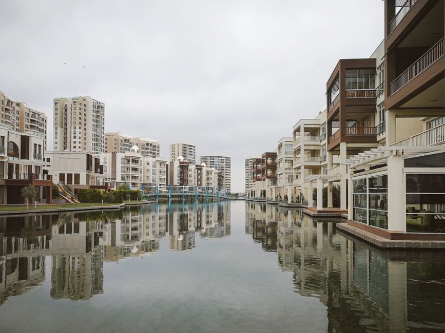 Modern residential buildings reflecting in a tranquil urban canal