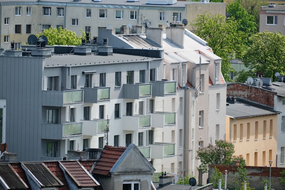 Contemporary apartment buildings in a vibrant city neighborhood with lush greenery.